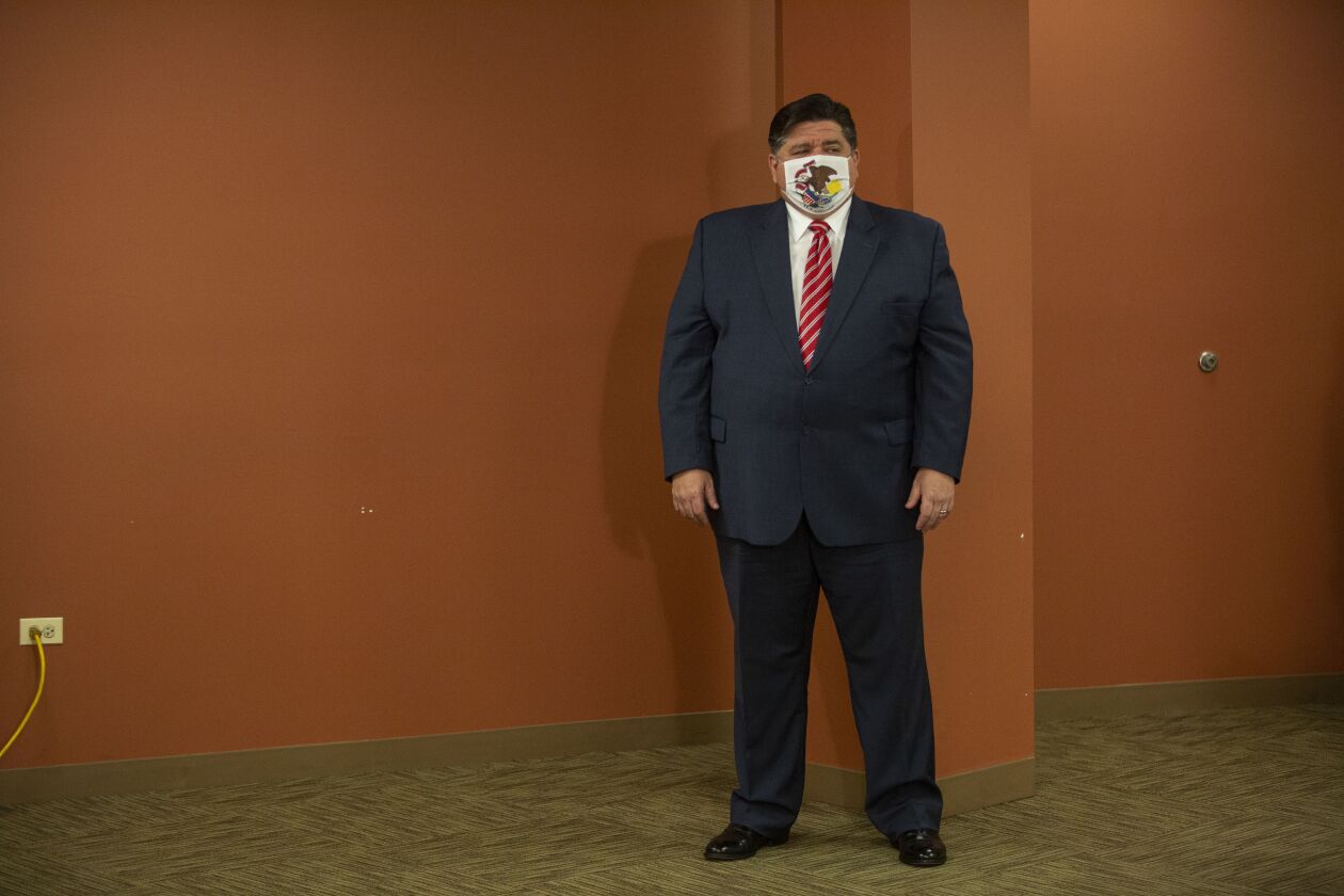 Gov. J.B. Pritzker listens to a speaker during a news conference on Tuesday.